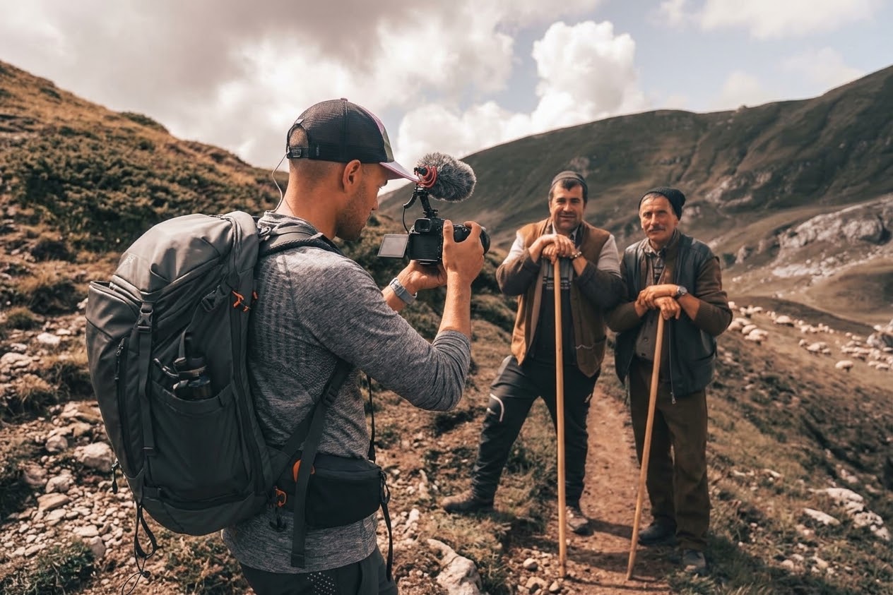 Laurent photographie deux hommes dans un paysage de montagne.