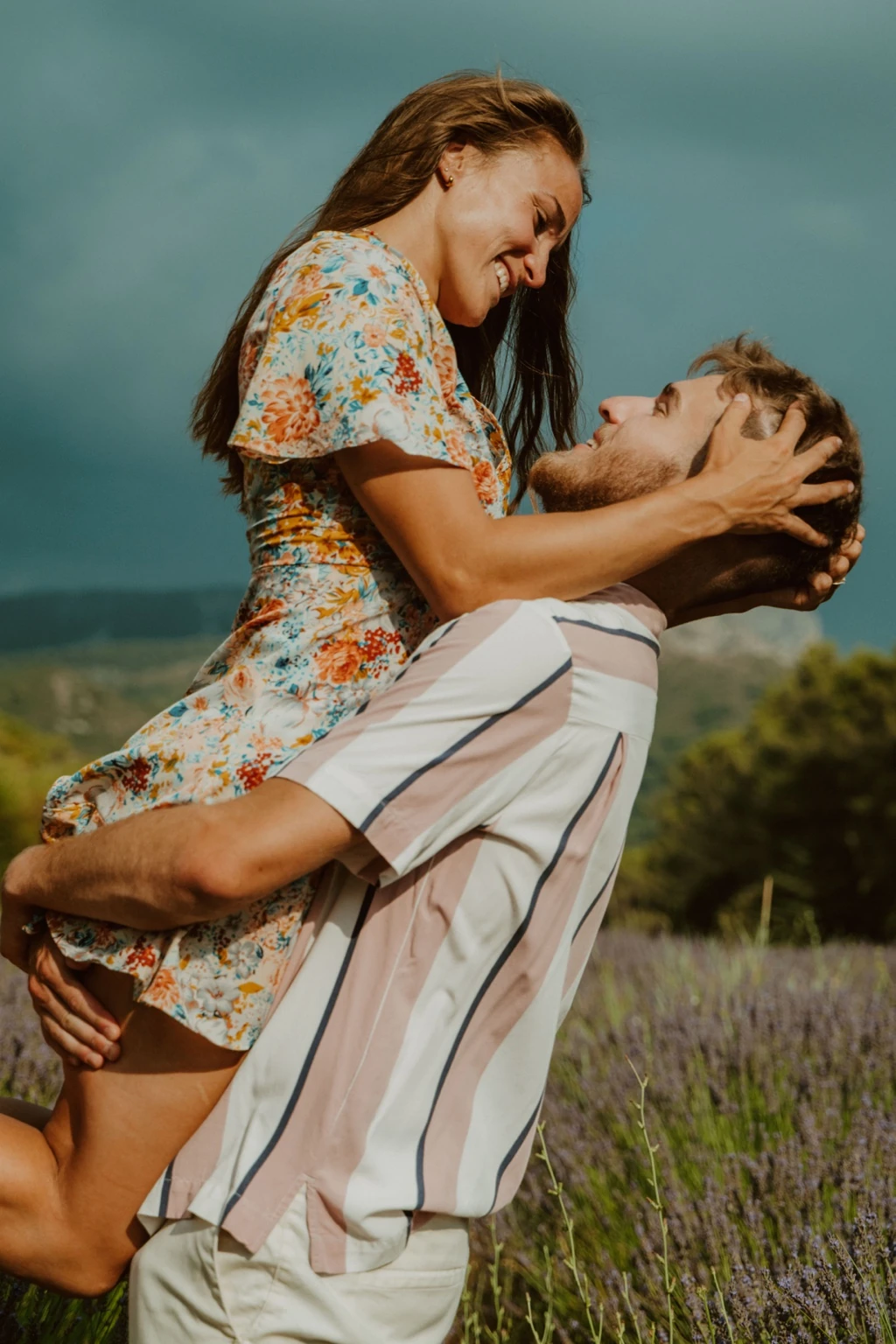 Théo porte Virginie dans ses bras, au milieu des herbes et des fleurs, près de la Sainte-Victoire.